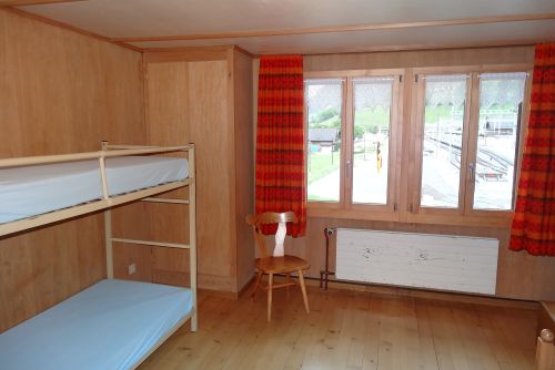 Ferienlager Zimmer mit Etagenbett und Blick aus Fenster.